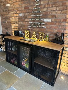 a bar with wine glasses and bottles on it in front of a brick wall that says bar