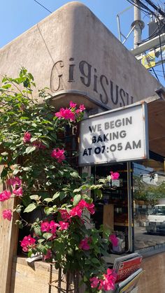 a sign that says we begin baking at 705 - 5 am in front of a building