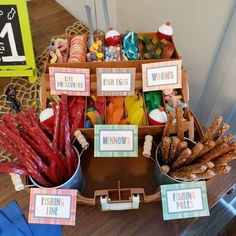 an assortment of candy and treats displayed in baskets on a table with signs that read fishing time