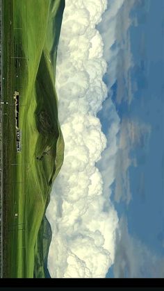 an aerial view of clouds and grass in the sky