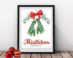 a christmas poster with the word mistle toer on it and two ornaments next to it