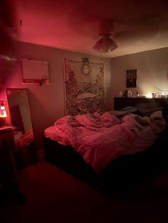 a bed in a room with red light coming from the ceiling