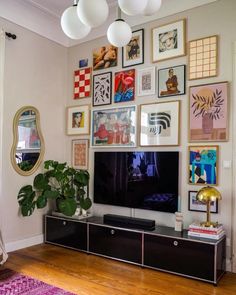 a living room with pictures on the wall and a large flat screen tv mounted to the wall