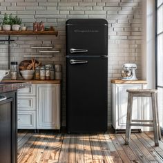 a black refrigerator freezer sitting inside of a kitchen next to a counter top oven