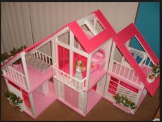 a doll house with pink walls and floors