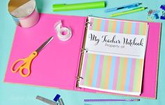 a pink binder with scissors, tape and other office supplies on top of it