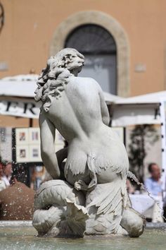 a white statue sitting on top of a fountain