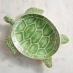 a green turtle shaped bowl sitting on top of a table