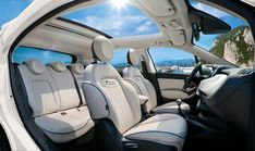 the interior of a car with its sunroofer and seats folded down looking out to sea