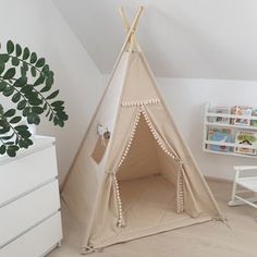 a teepee tent sitting in the corner of a room next to a white dresser