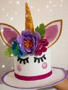 there is a cake decorated with flowers and a unicorn's head on top of it