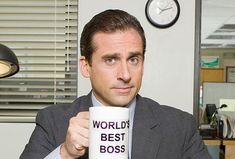 a man in a suit holding a coffee mug with the words world's best boss on it