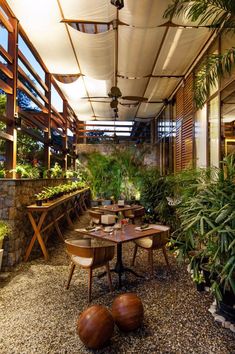 an outdoor dining area with tables, chairs and potted plants