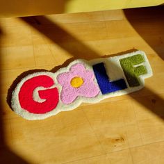 a rug with the word google spelled out on it and a flower in the middle