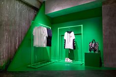 a green room with clothes and shoes on display