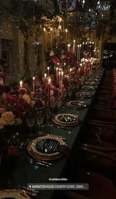 a long table is set with candles and plates for an elegant dinner or party event