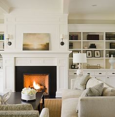 a living room filled with furniture and a fire place in the middle of a room