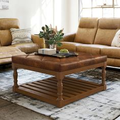 a living room with two couches, a coffee table and a rug on the floor