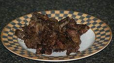 a plate full of cooked meat on a black and white checkerboard pattern table