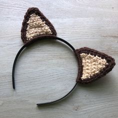 a crocheted cat ears headband on top of a wooden table