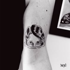 a woman's arm with a black and white tattoo design on the left inner arm