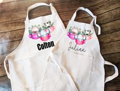 two personalized aprons are sitting on a wooden table with the name cotton written on them