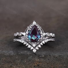 an engagement ring with a pear shaped blue topazte surrounded by white diamond accents