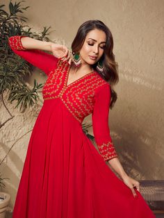 Malaika Arora's red zari embroidered flared kurta with sharara is an elegant winter essential perfect for your ethnic wardrobe. This calf-length A-line piece of pure beauty features a V-neck and three-quarter sleeves that are expertly embroidered with zari and machine weave. Crafted from georgette with crepe inner, it's a timeless addition to your closet. Dry clean only. TOP: Georgette, TOP INNER: Crepe, BOTTOM: Georgette with Crepe Inner, Dry Clean Red Anarkali Sharara For Festive Occasions, Festive Red Anarkali Style Sharara, Red Anarkali Style Sharara For Festive Season, Red Kurta For Navratri Festival, Red Long Sleeve Anarkali Set With Cutdana, Red Festive Kurta For Navratri, Eid Maxi Length Kurta With Dori Work, Maxi Length Kurta With Dori Work For Eid, Red Anarkali Set For Eid Festival