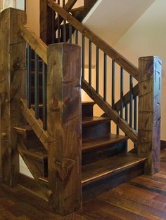 a wooden stair case next to a white wall and wood flooring in a home