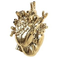 a gold heart shaped brooch sitting on top of a white surface