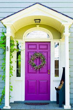 a purple front door with a wreath on it