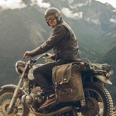 a man riding on the back of a motorcycle wearing a helmet and holding onto a bag