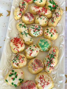 a white platter filled with cookies covered in frosting and sprinkles