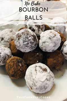 chocolate and powdered sugar balls on a white plate with bowls of powder in the background