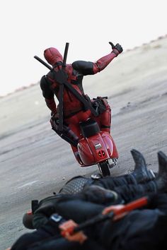 a dead man laying on the ground next to a motorcycle and another dead person with their hands in the air