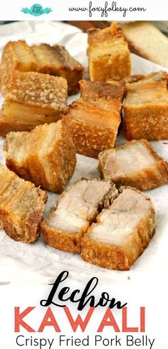 several pieces of meat sitting on top of a piece of wax paper next to bread