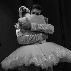 a man and woman hugging each other while wearing tutu skirts in black and white