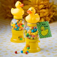 two yellow rubber ducks in a gum ball dispenser filled with candy balls