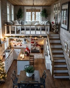 a living room filled with lots of furniture and christmas decorations on top of wooden floors