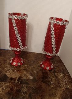 two red vases sitting on top of a counter