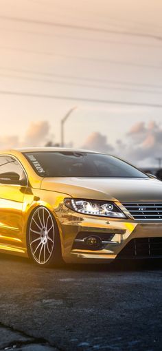 a yellow car is parked on the side of the road in front of some power lines