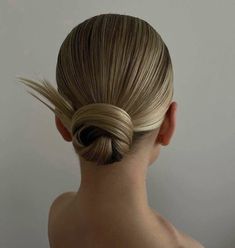 a woman with blonde hair in a low bun braided into a high pony tail