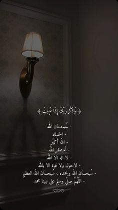 a lamp that is on the side of a wall in a dark room with arabic writing