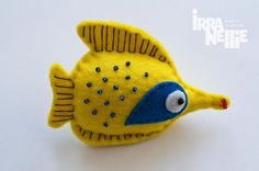 a yellow and blue fish brooch sitting on top of a table