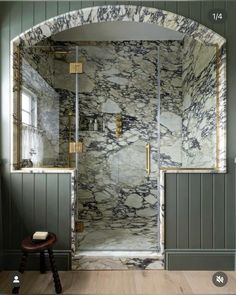 a walk in shower sitting inside of a bathroom next to a wooden floor and wall