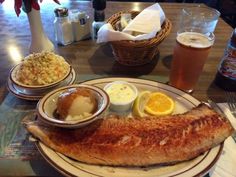 fish, potatoes and beer on a table at a restaurant