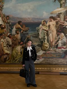 a woman standing in front of a painting