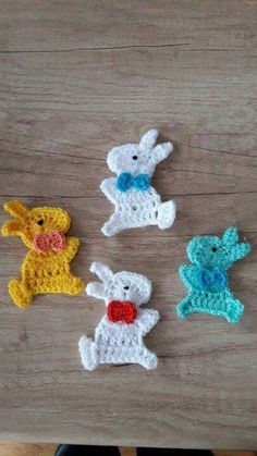 four crocheted animals sitting on top of a wooden table