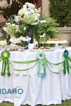 a table topped with lots of food on top of a lush green field covered in flowers