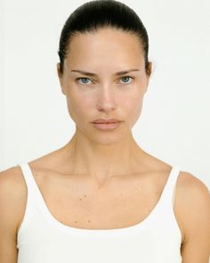 a woman in white tank top posing for the camera